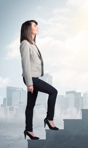 Businesswoman climbing up a concrete staircase concept on city background
